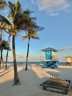 a lifeguard hut on the beach with palm trees