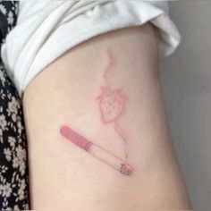 a small tattoo on the back of a woman's leg with a pencil in it