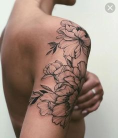 a woman's arm with flowers on it and the back of her body in black ink