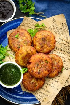 some food is on a blue plate with sauces and parsley next to it