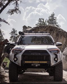 the front end of a white four - doored toyota truck parked on a rocky terrain