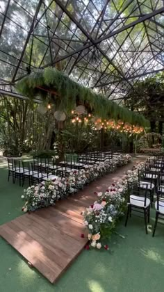 an outdoor ceremony setup with flowers and greenery on the aisle, surrounded by chairs