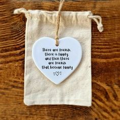 a white heart shaped ornament hanging from a string on top of a wooden table