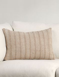 a white couch with a beige pillow on it