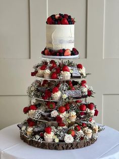 a three tiered cake with berries on top