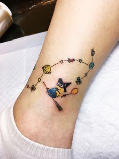 a person with a small tattoo on their foot that has an image of a cat flying through the sky