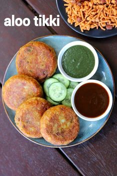 a plate with some food on it next to another plate filled with vegetables and sauces