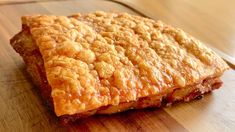 a piece of food sitting on top of a wooden cutting board