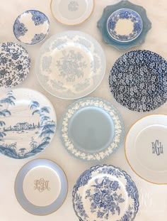 blue and white plates with monogrammed names are arranged in a circle on a table