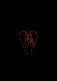 a hand holding a heart in the middle of a black background with red writing on it