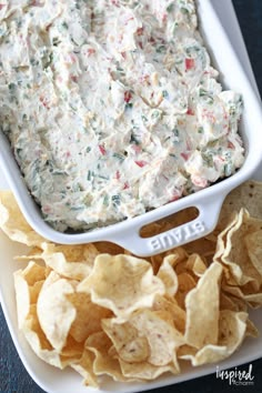 a white dish filled with dip and chips