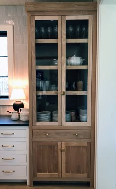 a wooden cabinet with glass doors in a kitchen