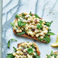 two pieces of bread topped with macaroni salad on top of a marble counter