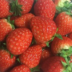 a pile of ripe strawberries sitting on top of each other