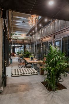 an indoor area with tables, chairs and potted plants