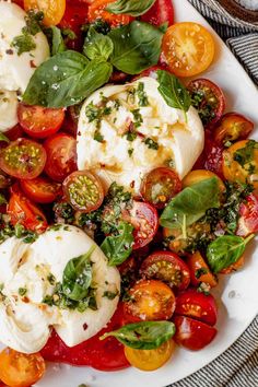 a white plate topped with tomatoes and mozzarella