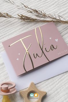 a pink greeting card with the word julia on it next to some crafting supplies