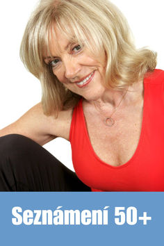 an older woman with blonde hair and red shirt smiling at the camera, in front of a white background