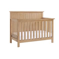 a small wooden crib with white sheets on the bottom and side rails, against a white background