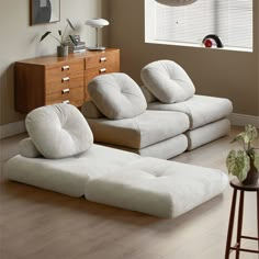 a living room filled with white furniture next to a window