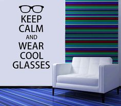 a white chair sitting in front of a wall with the words keep calm and wear cool glasses