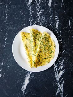 two pieces of omelette on a plate with parsley sprinkled over it