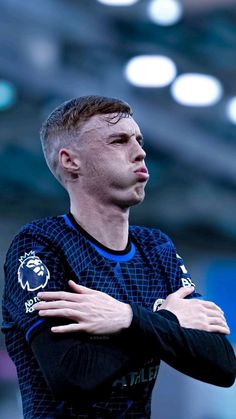 a soccer player with his arms crossed looking up