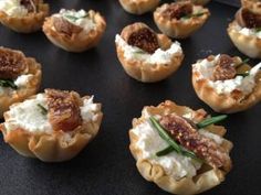 small appetizers are arranged on a black surface