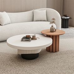 a white couch sitting next to a wooden table on top of a carpeted floor