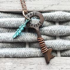 a key necklace with an arrow and the words free spirit on it