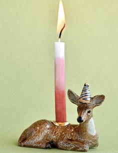 a deer figurine sitting next to a lit candle