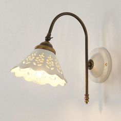 a light that is on the side of a wall next to a white wallpaper