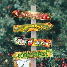 a wooden pole with several signs on it in front of some bushes and trees,