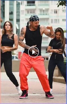 a man in black shirt and red pants doing a dance move with two other people