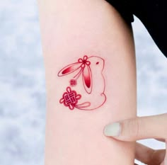 a woman's arm with a red tattoo on it