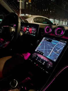 the interior of a car with pink lights and dashboard controls, including an electronic display