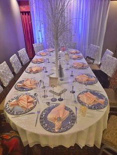 the table is set with silver and pink place settings