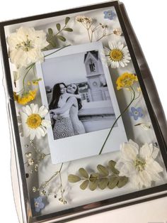 a photo frame with flowers and leaves on it