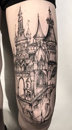 a woman's thigh with a castle tattoo on it