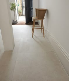 a chair sitting in the middle of a hallway next to a doorway with a potted plant on it