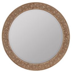 a round mirror with leaves on it