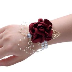 a close up of a person's hand wearing a bracelet with flowers on it