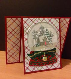 two christmas cards, one with a snow globe and the other with a house on it