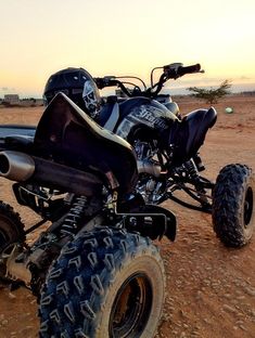 an atv is parked in the desert at sunset