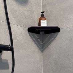 a soap dispenser is placed on the wall next to a shower head