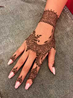 a woman's hand with henna tattoos on it