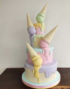 a multi - tiered cake with ice cream cones on top and other decorations around it