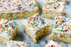 several pieces of cake with white frosting and sprinkles