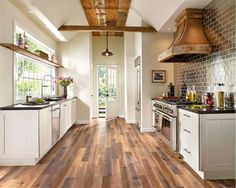 an open kitchen with white cabinets and wood flooring on the walls is pictured in this image