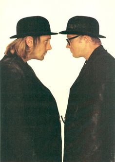 two men in black hats are facing each other